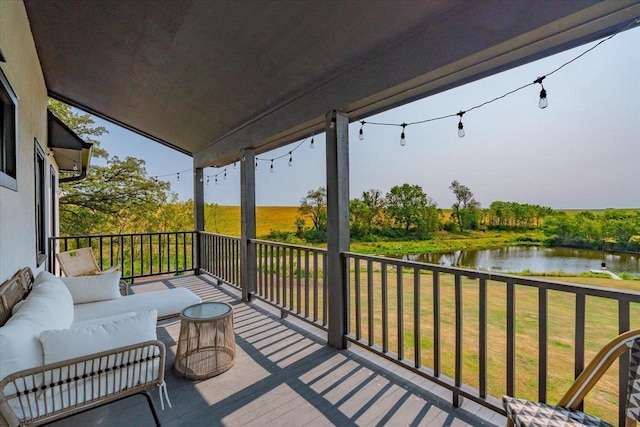 deck with a water view and a lawn