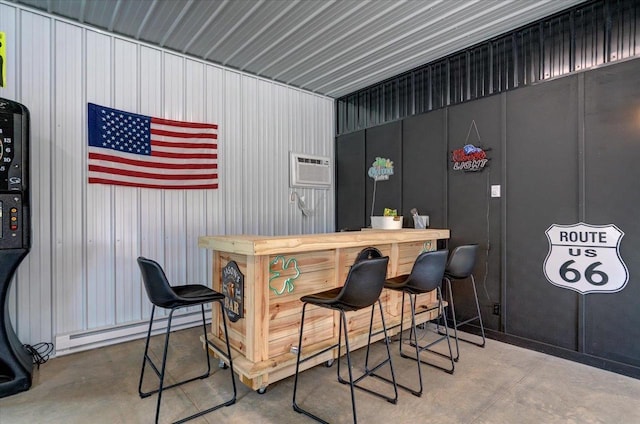 bar with a baseboard radiator, a wall mounted air conditioner, and concrete floors