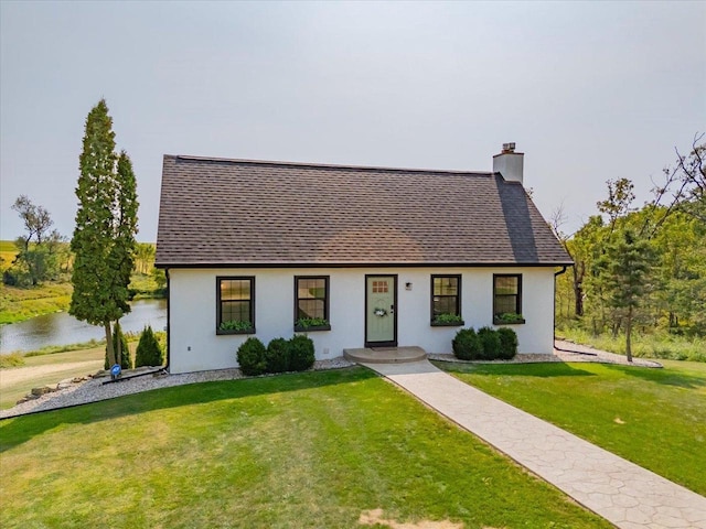 view of front facade featuring a water view and a front lawn