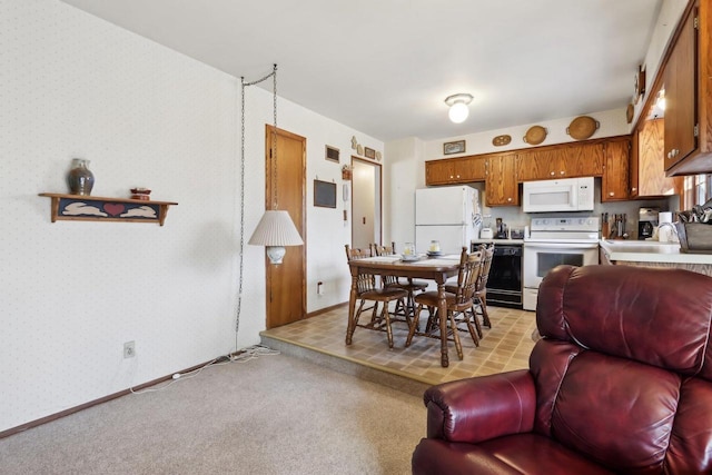 dining area featuring sink and light carpet