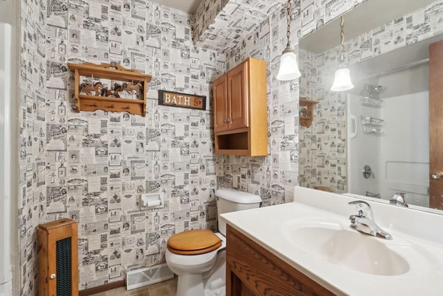 bathroom featuring vanity, toilet, and a shower