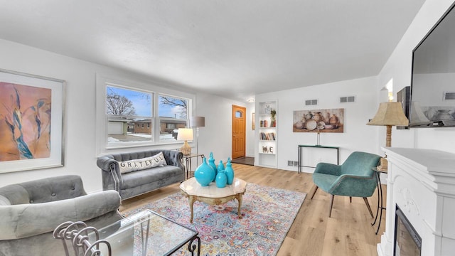 living room with a fireplace and light hardwood / wood-style floors