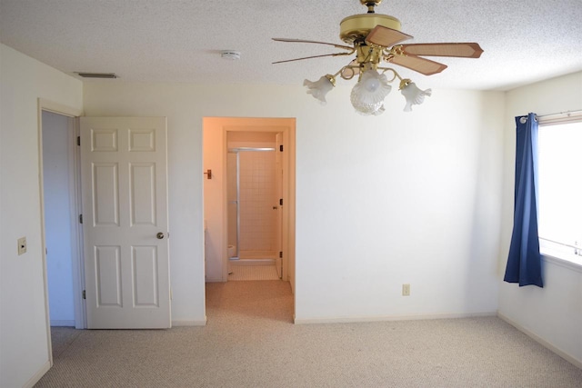 unfurnished room with baseboards, light carpet, visible vents, and a textured ceiling