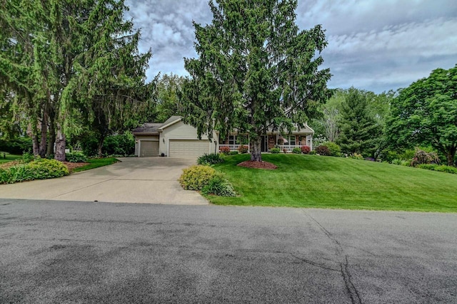 view of front of house with a garage, concrete driveway, and a front lawn