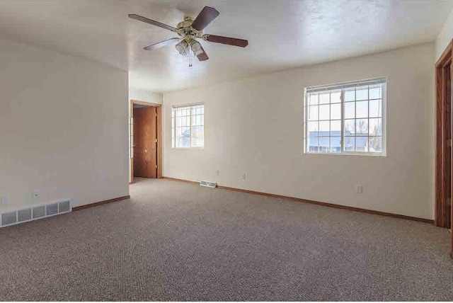 spare room featuring ceiling fan and carpet