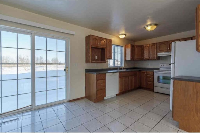 kitchen with sink, light tile patterned floors, and white appliances