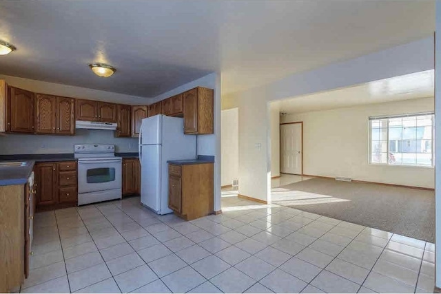 kitchen featuring light tile patterned flooring, sink, and white appliances