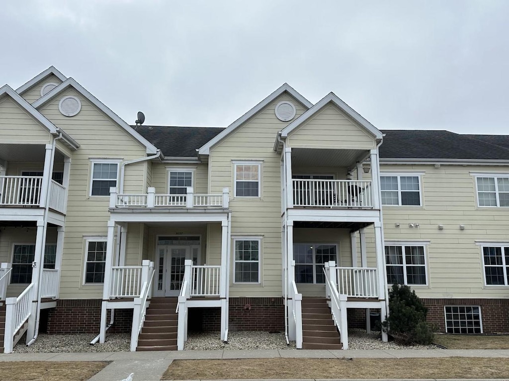 view of front facade with covered porch and a shingled roof