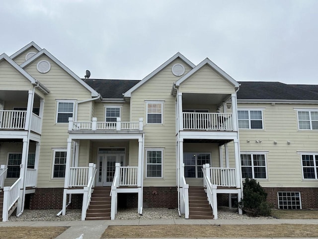 view of front facade with covered porch and a shingled roof
