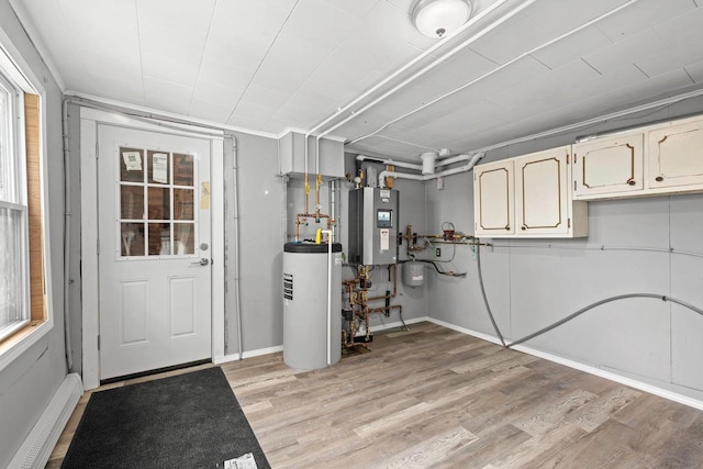 basement featuring light hardwood / wood-style floors and water heater