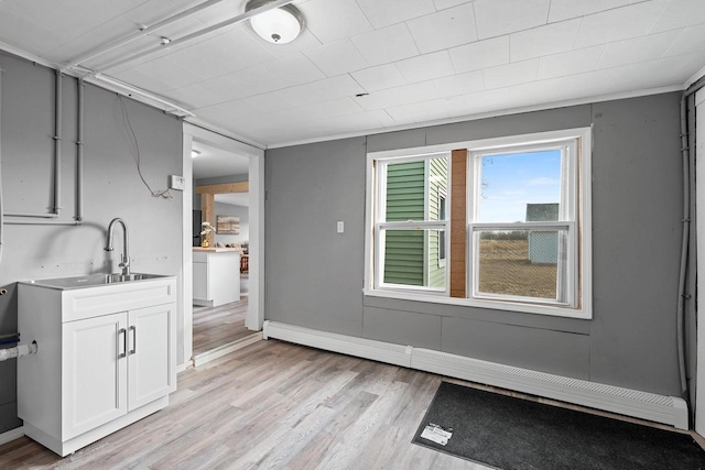 interior space featuring a baseboard heating unit, light hardwood / wood-style flooring, and sink