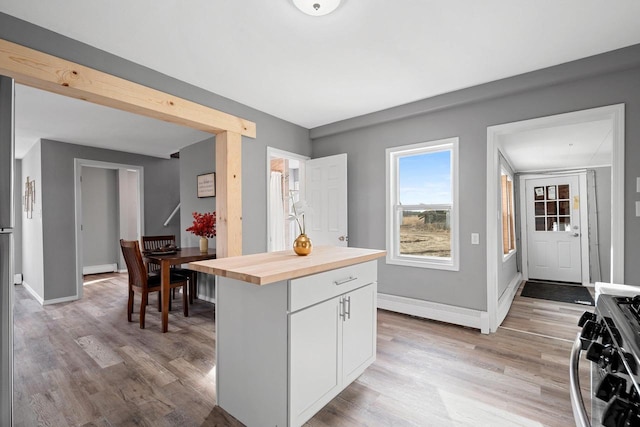 kitchen with wood counters, gas range, light hardwood / wood-style floors, and white cabinetry