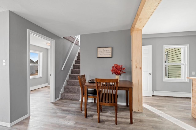 dining space with light wood-type flooring and baseboard heating