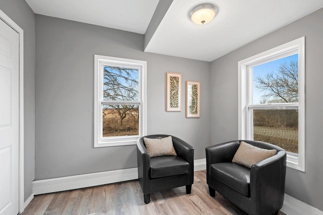 sitting room featuring a baseboard radiator, a healthy amount of sunlight, and light hardwood / wood-style flooring