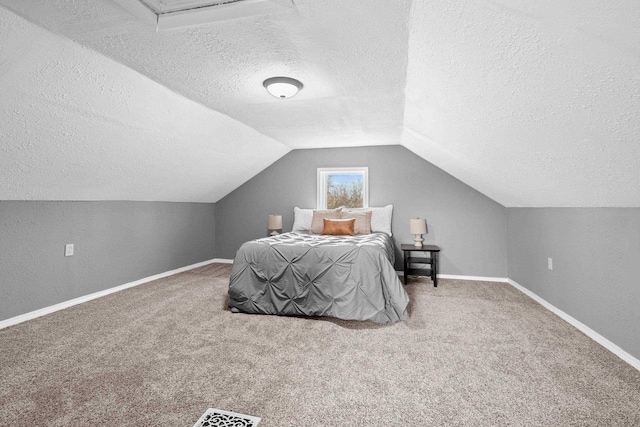 bedroom with vaulted ceiling, a textured ceiling, and carpet