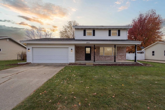 front facade featuring a garage, a yard, and a porch