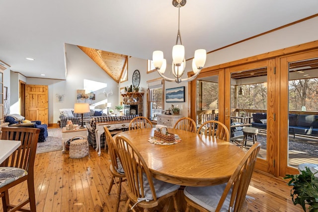 dining room with lofted ceiling, light wood-type flooring, and a chandelier