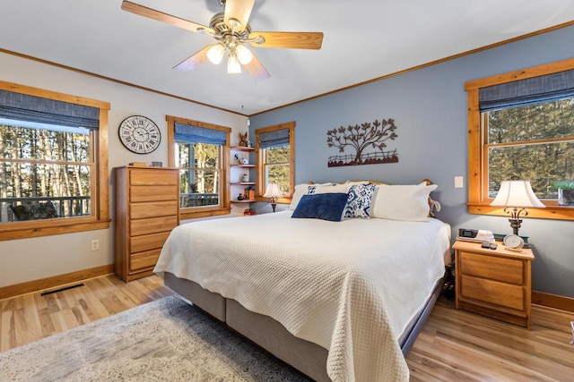 bedroom with ornamental molding, ceiling fan, and light hardwood / wood-style floors