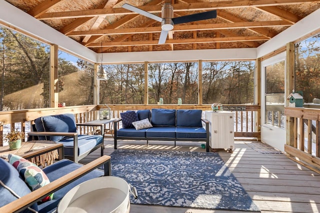 sunroom with ceiling fan and vaulted ceiling