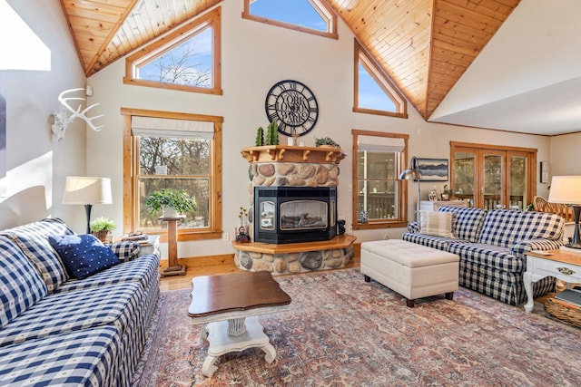 living room with wood ceiling, a stone fireplace, hardwood / wood-style flooring, and a wealth of natural light