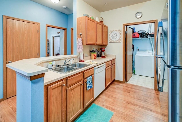 kitchen with stainless steel refrigerator, dishwasher, sink, independent washer and dryer, and kitchen peninsula