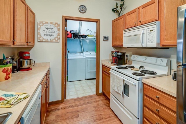 kitchen featuring separate washer and dryer, white appliances, and light hardwood / wood-style floors