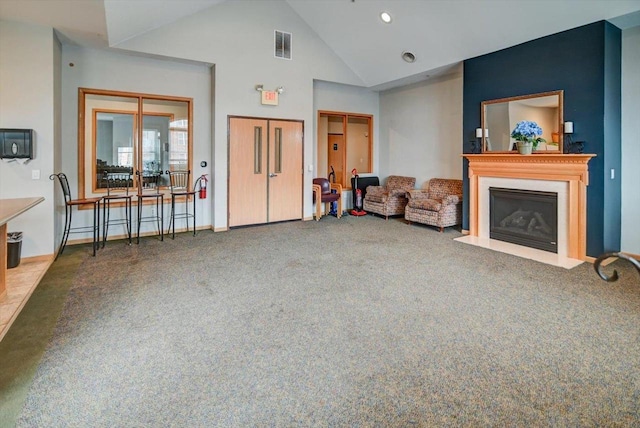 carpeted living room featuring high vaulted ceiling