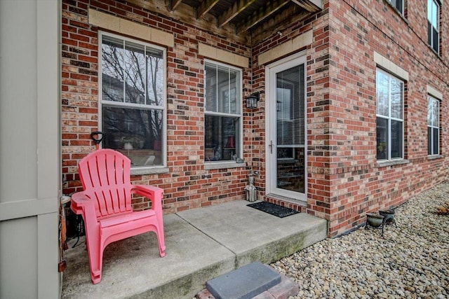 view of exterior entry with a patio area