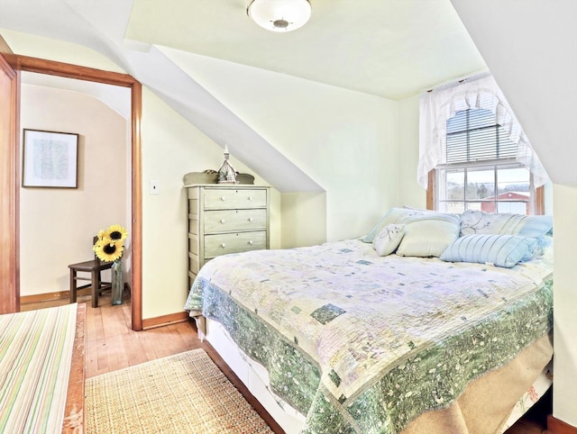 bedroom with hardwood / wood-style flooring and lofted ceiling