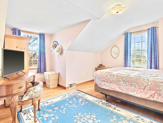 bedroom featuring lofted ceiling and light hardwood / wood-style flooring