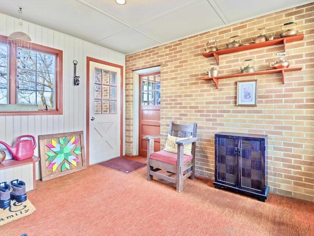 sitting room with brick wall and carpet