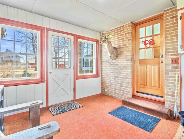 interior space featuring brick wall and carpet