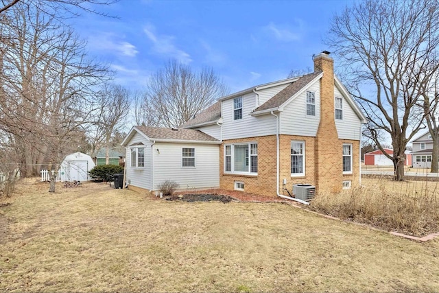 rear view of property with a storage shed, a yard, and central air condition unit