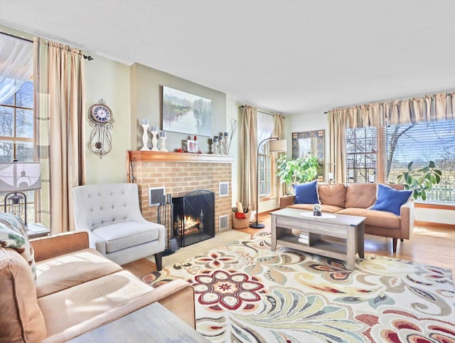 living room with a brick fireplace and hardwood / wood-style flooring