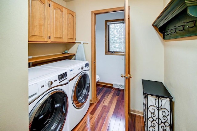 laundry room featuring cabinets, dark hardwood / wood-style flooring, and washer and clothes dryer