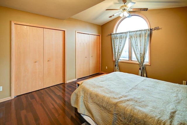 bedroom with multiple closets, ceiling fan, and dark hardwood / wood-style flooring