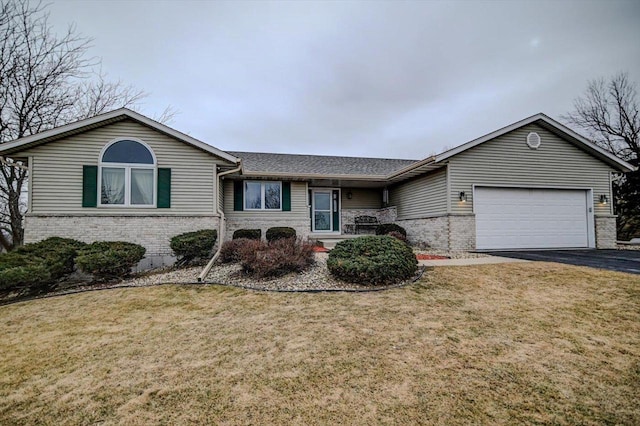 ranch-style house with a garage and a front lawn