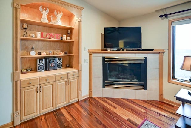 living room featuring hardwood / wood-style flooring, a tile fireplace, and a wealth of natural light