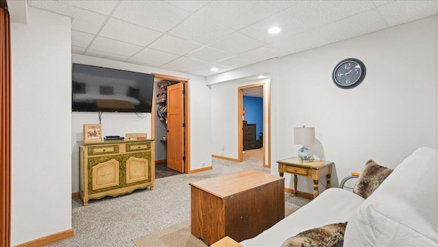 carpeted living room with a drop ceiling