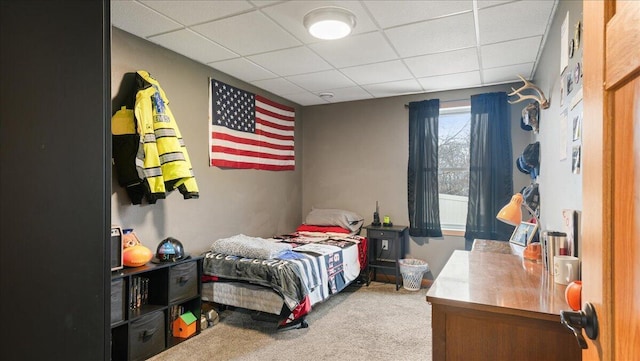 bedroom featuring a paneled ceiling and carpet floors