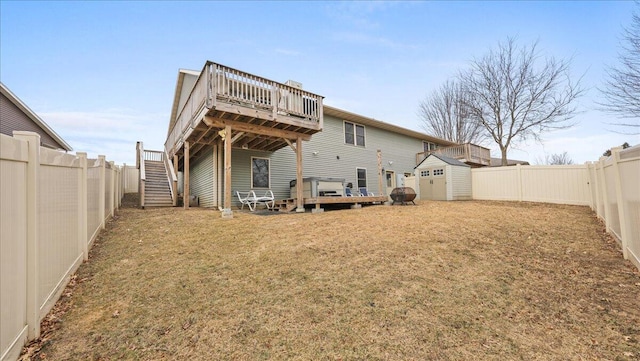 rear view of house with a wooden deck and a storage unit