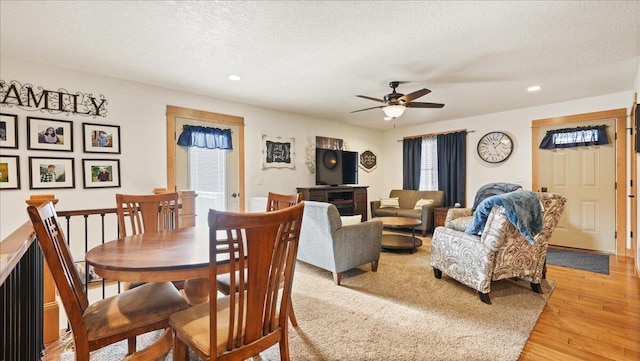 dining area with hardwood / wood-style floors, a textured ceiling, and ceiling fan