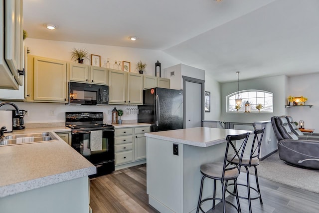 kitchen with lofted ceiling, sink, hanging light fixtures, black appliances, and dark wood-type flooring