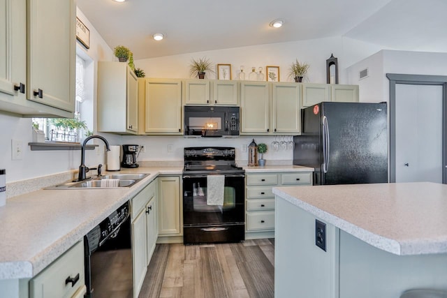 kitchen featuring sink, vaulted ceiling, light hardwood / wood-style flooring, cream cabinets, and black appliances