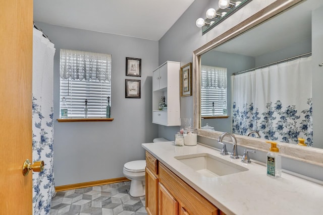 bathroom with vanity, a wealth of natural light, and toilet