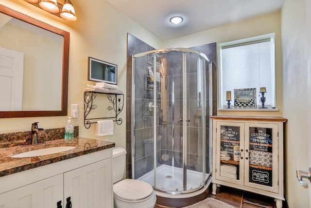 bathroom featuring walk in shower, vanity, and toilet