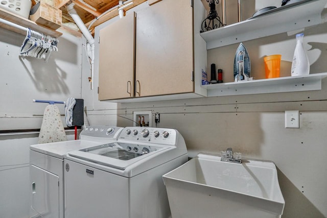 laundry area featuring sink, washer and clothes dryer, and cabinets