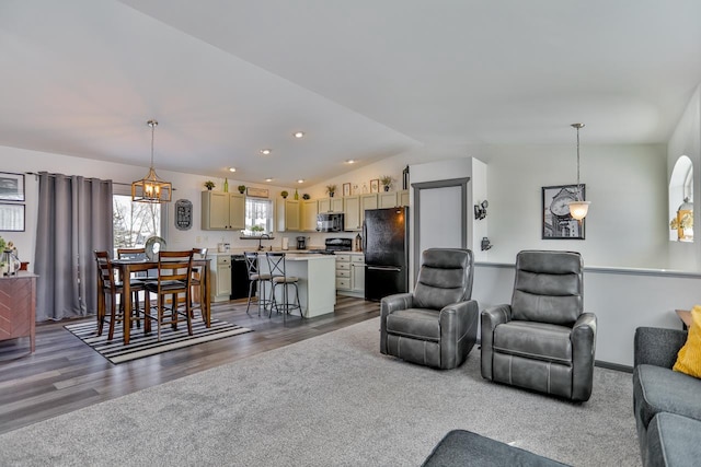 living room featuring lofted ceiling, sink, and dark hardwood / wood-style floors