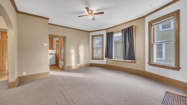 empty room featuring light carpet, ornamental molding, and ceiling fan