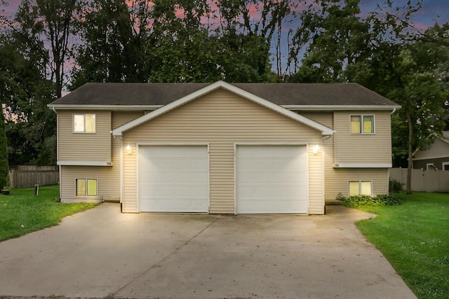 split foyer home with a garage and a yard